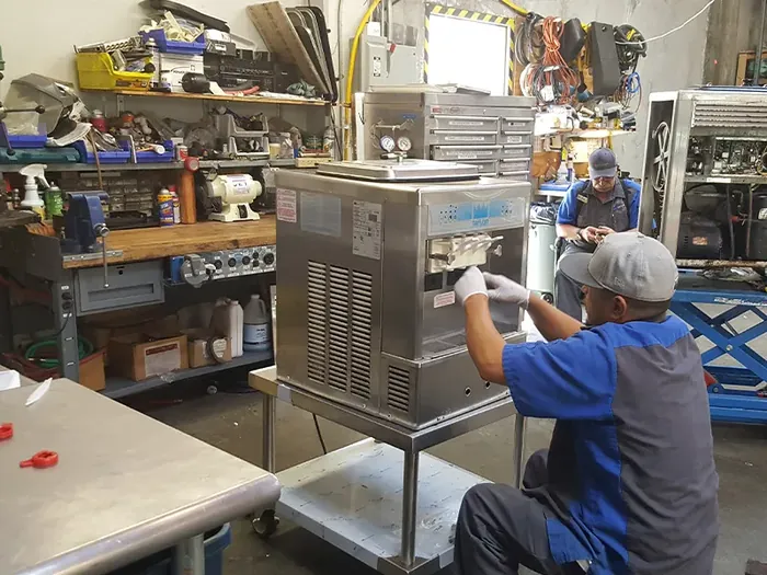 Technician servicing commercial kitchen food equipment
