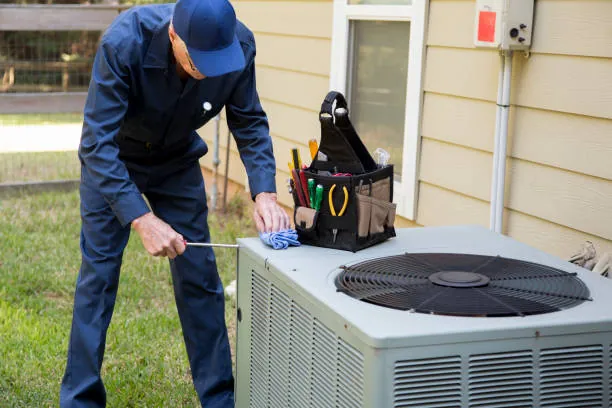 Technician servicing a rooftop HVAC condenser unit