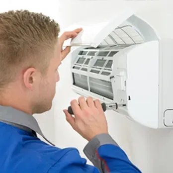 Technician repairing a commercial refrigeration unit